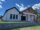 Charming home featuring white siding, black trim, a stone retaining wall, and a covered porch at 520 Rockbridge Rd, Lilburn, GA 30047