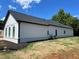 Exterior shot showcasing white vertical siding with black trim and dark roof on a sunny day at 520 Rockbridge Rd, Lilburn, GA 30047