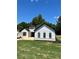 Modern farmhouse with white siding, black trim, and a well-manicured lawn, all under a clear blue sky at 520 Rockbridge Rd, Lilburn, GA 30047