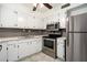The updated kitchen features stainless steel appliances, bright white cabinets, and modern backsplash, ready for gourmet experiences at 123 Maison Nw Pl, Atlanta, GA 30327