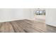 Bright living room with recently installed gray-toned hard surface flooring and a doorway to a sunroom or patio at 123 Maison Nw Pl, Atlanta, GA 30327