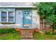 Close up of home featuring blue front door with brick steps and established landscaping at 1406 Springleaf Se Cir, Smyrna, GA 30080