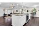 Open kitchen with granite island, stainless appliances and eat-in seating flowing into the living room at 4180 Gables Pl, Buford, GA 30519