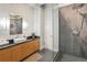 Modern bathroom with a vessel sink, wood cabinets, and large walk-in shower with gray tile at 878 Peachtree Ne St # 704, Atlanta, GA 30309