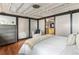 Comfortable bedroom with large frosted glass dividers, a soft chair, and hardwood floors at 878 Peachtree Ne St # 704, Atlanta, GA 30309