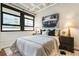 Bright bedroom featuring a large window with city views, hardwood floors, and modern furnishings at 878 Peachtree Ne St # 704, Atlanta, GA 30309