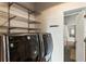 Convenient laundry closet with modern washer and dryer, plus metal shelving for storage at 878 Peachtree Ne St # 704, Atlanta, GA 30309