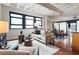 Stylish living room showcases modern furniture, large windows, and hardwood floors; a dining area and bedroom are in the background at 878 Peachtree Ne St # 704, Atlanta, GA 30309
