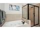 Bathroom showcasing a soaking tub and separate glass-enclosed shower with tiled surround at 190 Marion Ne Pl, Atlanta, GA 30307