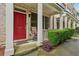 Inviting covered front porch with red door, chair seating, and manicured green hedges at 190 Marion Ne Pl, Atlanta, GA 30307