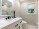Modern bathroom with white vanity, sleek black fixtures, framed mirror, and large window providing natural light at 2263 Hill Creek Way, Marietta, GA 30062