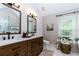 Bright bathroom featuring dual sinks, wooden cabinets, and modern fixtures, complemented by white walls at 2263 Hill Creek Way, Marietta, GA 30062