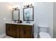 Bathroom featuring dual sinks, wooden cabinets, modern fixtures, and a white tiled wall at 2263 Hill Creek Way, Marietta, GA 30062