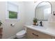 Chic half bath featuring a modern vanity, black faucet, arched mirror, and neutral color palette at 2263 Hill Creek Way, Marietta, GA 30062