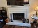 Close up on the fireplace with a white mantle and dark iron fireplace tools at 2263 Hill Creek Way, Marietta, GA 30062