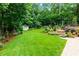 Beautifully landscaped backyard with stone steps, lush greenery, colorful plants, and mature trees at 2263 Hill Creek Way, Marietta, GA 30062