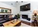 Cozy living room with a fireplace, dark wood floors, leather sofa, and a decorative mirror at 2263 Hill Creek Way, Marietta, GA 30062