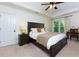 Bedroom featuring a dark wood bed frame, neutral walls, a ceiling fan, and a desk with chair at 2263 Hill Creek Way, Marietta, GA 30062