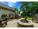 Stone patio features a built-in fire pit, wooden chairs, and string lights for outdoor entertaining at 2263 Hill Creek Way, Marietta, GA 30062