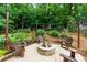 Beautiful backyard patio includes a stone fire pit, wooden chairs, and string lights for ambiance at 2263 Hill Creek Way, Marietta, GA 30062