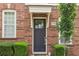 Close-up of a brick townhome's front door with a covered entrance and neatly trimmed bushes at 306 Masons Row, Marietta, GA 30060