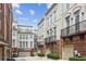 Street view of upscale townhomes featuring brick accents, balconies and well-manicured landscaping at 306 Masons Row, Marietta, GA 30060