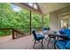 Inviting back deck with wooden railing, comfortable blue seating, and view of lush green trees at 3157 Perimeter Cir, Buford, GA 30519