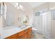 Bright bathroom featuring wood vanity, white countertop, large mirror, and shower-tub combo with white tile at 3157 Perimeter Cir, Buford, GA 30519