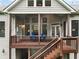 View of the covered deck with wood railings, outdoor furniture, and stairs leading down to the backyard at 3157 Perimeter Cir, Buford, GA 30519