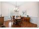 Elegant dining room featuring hardwood floors, wainscoting, a chandelier, and ample natural light at 3157 Perimeter Cir, Buford, GA 30519