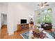 Cozy living room with hardwood floors, fireplace, and ample natural light at 3157 Perimeter Cir, Buford, GA 30519