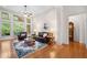 Bright living room with soaring windows, hardwood floors, ceiling fan, and a decorative area rug at 3157 Perimeter Cir, Buford, GA 30519