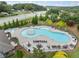 Aerial view of the community pool surrounded by lounge chairs, tables, and manicured landscaping at 3157 Perimeter Cir, Buford, GA 30519