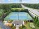 Community tennis courts surrounded by trees and greenery near sidewalks and roadways at 3157 Perimeter Cir, Buford, GA 30519