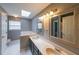 Well-lit bathroom featuring double sinks, a skylight, and tile flooring at 4228 Lakes End Nw Dr, Kennesaw, GA 30144