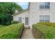 View of stucco home featuring manicured bushes and grey front door at 4228 Lakes End Nw Dr, Kennesaw, GA 30144