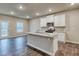 Open kitchen with a center island, granite countertops, white cabinets, and stainless steel appliances at 45 Avian Way, Auburn, GA 30011