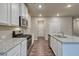 Modern kitchen with white cabinets, granite countertops, stainless steel appliances, and wood-look floors at 45 Avian Way, Auburn, GA 30011