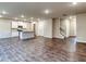 Open-concept living space featuring a kitchen with an island, white cabinets and wood-look floors throughout at 45 Avian Way, Auburn, GA 30011