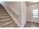 Carpeted staircase leads to the upper level, complemented by a nearby exterior door and wood-look floors at 45 Avian Way, Auburn, GA 30011