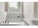Bright bathroom features a soaking tub under a window with modern fixtures at 16 Kentucky Ne Walk, Cartersville, GA 30121