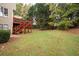 Backyard view of a two-story home with a deck, stairs, and green lawn at 4651 Oakleigh Manor Dr, Powder Springs, GA 30127