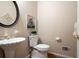 Powder room with a pedestal sink, hardwood floors, decorative mirror and neutral walls at 4651 Oakleigh Manor Dr, Powder Springs, GA 30127
