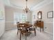 Elegant dining room featuring a chandelier, crown molding, and a traditional wooden table set at 4651 Oakleigh Manor Dr, Powder Springs, GA 30127