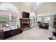Spacious living room with a stone fireplace, large windows, and comfortable leather sofas at 4651 Oakleigh Manor Dr, Powder Springs, GA 30127