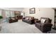 Open concept living room with comfortable leather seating, hardwood floors, a fireplace, and dining area at 4651 Oakleigh Manor Dr, Powder Springs, GA 30127