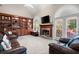 Spacious living room with built-in bookshelves, a stone fireplace, large windows, and comfortable leather seating at 4651 Oakleigh Manor Dr, Powder Springs, GA 30127