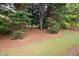 Tree line surrounds the yard with well maintained lawn and pine straw ground cover at 4651 Oakleigh Manor Dr, Powder Springs, GA 30127