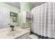 Bathroom showcasing a vanity sink, toilet, decorative art, and striped shower curtain at 1355 Pinebreeze Way, Marietta, GA 30062