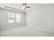 Bright bedroom featuring neutral carpet, a ceiling fan, and large windows offering scenic views at 189 Park Ln, Fairburn, GA 30213